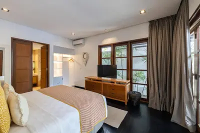 a bedroom with a bed and a tv and a window at Villa Dee 6 in Seminyak