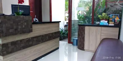 a counter with a tv and a chair in a room at D'Pande Kuta in Kuta