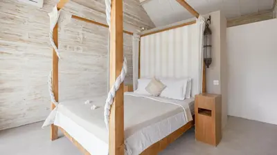 a bedroom with a bed and a wooden bed frame at Villa Du Ho by Villa Finder in Kerobokan