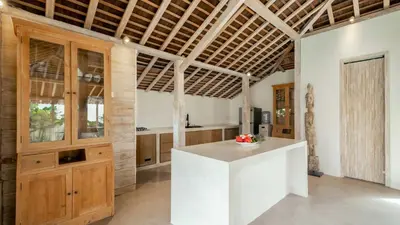 a kitchen with a white counter and wooden ceilings at Villa Du Ho by Villa Finder in Kerobokan