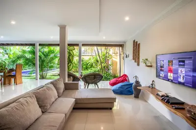 a living room with a couch and a flat screen tv at Villa Rani 3 in Seminyak