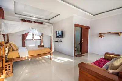 a bedroom with a bed and a couch in a room at Villa Rani 3 in Seminyak