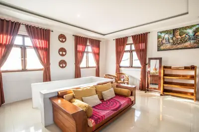 a living room with a couch and some windows at Villa Rani 3 in Seminyak