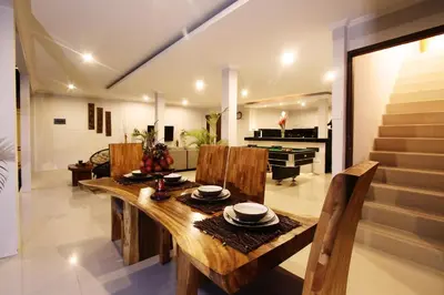 a dining room with a table and a piano at Villa Rani 3 in Seminyak