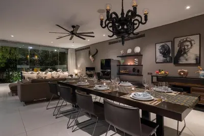 a dining room and living room with a table and chairs at Villa Balimu Seminyak in Seminyak