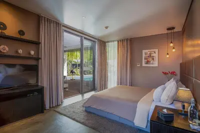 a bedroom with a bed and a large window at Villa Balimu Seminyak in Seminyak