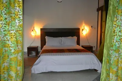 a bedroom with a bed with two lamps on the wall at Villa Una in Seminyak