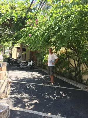 a man standing in the street under a tree at Villa Una in Seminyak