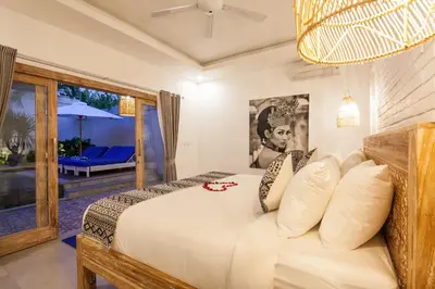 a bedroom with a bed with a view of a patio at Ambermoon Villas in Seminyak