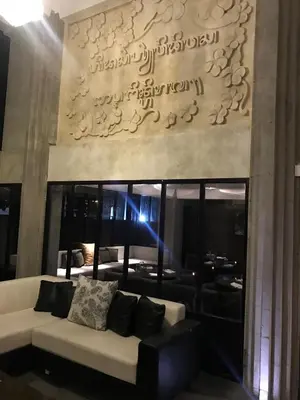 a living room with a white couch in front of a wall at Anshel Hotel Seminyak in Seminyak