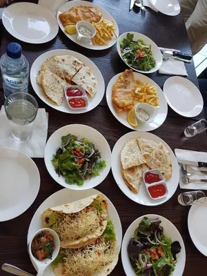 a wooden table with plates of food on it at Anshel Hotel Seminyak in Seminyak