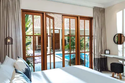 a bedroom with a bed and a view of a pool at Villa Alliv in Seminyak