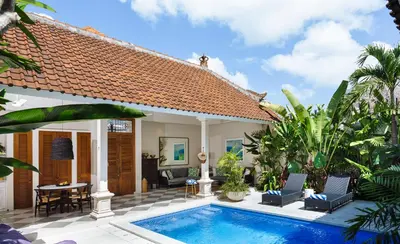 a villa with a swimming pool in front of a house at Villa Alliv in Seminyak