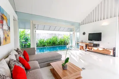 a living room with a couch and a tv at White Villa in Seminyak