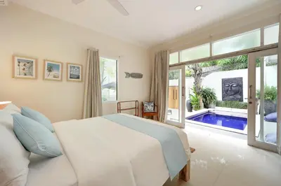a bedroom with a bed and a swimming pool at Villa Alba in Seminyak