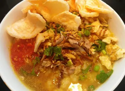 a white bowl of food with soup and chips at The Rani Garden Bed & Breakfast in Denpasar