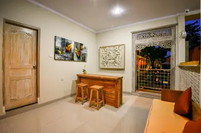 a living room with a piano and a window at The Rani Garden Bed & Breakfast in Denpasar