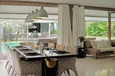 a dining table and chairs in a living room at Maya Villa - Seminyak in Seminyak