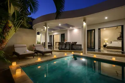 a villa with a swimming pool at night at Villa Maharani in Seminyak