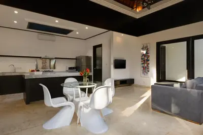 a kitchen with a glass table and white chairs at Villa Maharani in Seminyak
