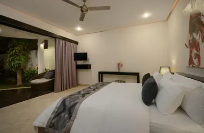 a bedroom with a large white bed and a couch at Villa Maharani in Seminyak
