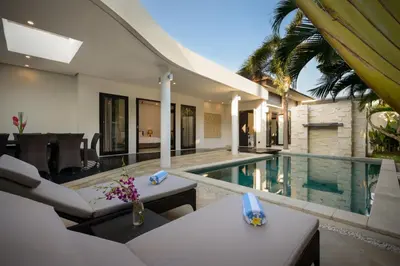a villa with a swimming pool and a house at Villa Maharani in Seminyak