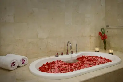 a bath tub filled with red petals in a bathroom at Villa Maharani in Seminyak