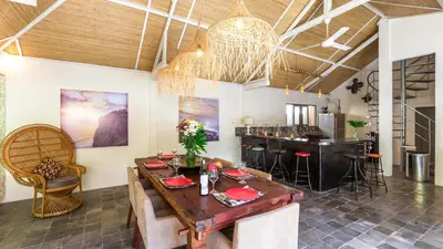 a dining room with a table and a bar at Luxury Villa Kudeta 300m BEACH and heart of Seminyak in Seminyak