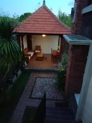 an outdoor patio with a pavilion with chairs and tables at D'puja Home Stay and Spa in Nusa Dua