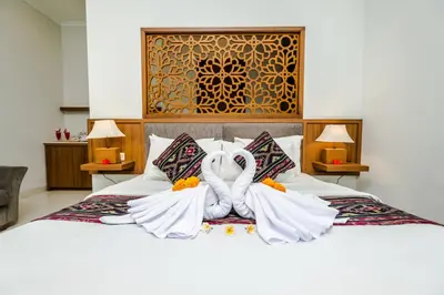 a bedroom with a large bed with white sheets at Mahana Living in Denpasar