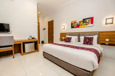 a bedroom with a large bed and a television at Mahana Living in Denpasar