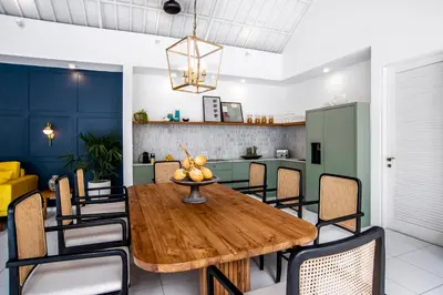 a dining room with a wooden table and chairs at The Beach House in Canggu