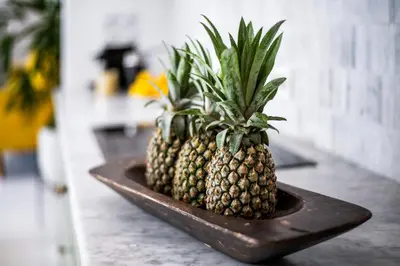 two pineapples sitting on a plate on a counter at The Beach House in Canggu