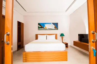 a bedroom with a bed and a television in it at Apple Villa & Suite Seminyak in Seminyak