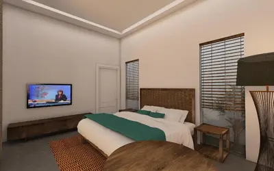 a bedroom with a bed and a tv on the wall at Apple Villa & Suite Seminyak in Seminyak