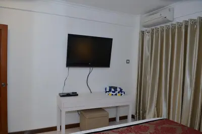 a living room with a tv on a white table at Sofi Apartment at Jayakarta Residence in Legian