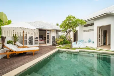 a villa with a swimming pool and a house at Villa Dipta in Seminyak