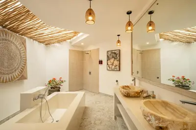 a bathroom with a large tub and a sink at Villa Dipta in Seminyak
