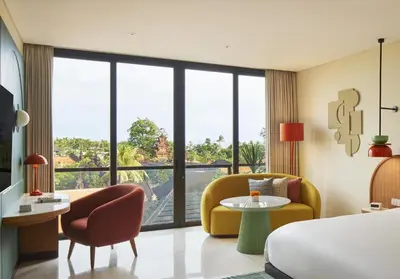 a hotel room with a bed and a table and chairs at Kleo Seminyak, part of JdV by Hyatt in Seminyak