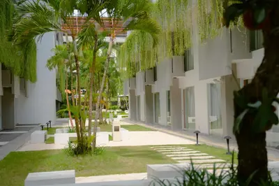 a courtyard with palm trees in a building at Tijili Hotel Benoa in Nusa Dua