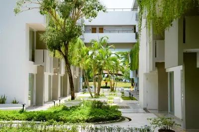 an internal courtyard of a building with palm trees at Tijili Hotel Benoa in Nusa Dua