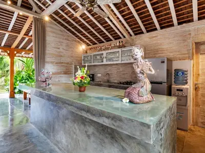 a kitchen with a concrete counter with a statue at Mannao Estate by Villa Finder in Kerobokan