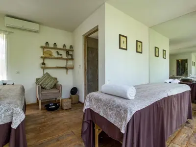 a bedroom with two twin beds and a chair at Mannao Estate by Villa Finder in Kerobokan