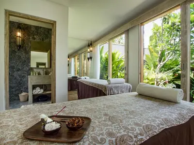 a bedroom with a bed with a tray of food on it at Mannao Estate by Villa Finder in Kerobokan
