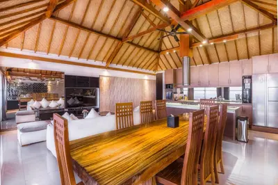 a kitchen and dining room with a wooden table and chairs at Imani Suites in Seminyak