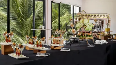 a black table with plates of food on it at Royal Tulip Springhill Resort Jimbaran in Jimbaran