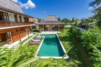 a swimming pool in a yard next to a house at Alea Estate in Kerobokan