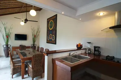 a kitchen and dining room with a sink and a table at 4BR Villa Selasa - Minggu Villas Seminyak in Seminyak