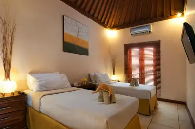 a hotel room with two beds and a television at 4BR Villa Selasa - Minggu Villas Seminyak in Seminyak