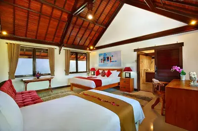 a hotel room with two beds and a desk at Alysha Villa Seminyak Beachside By Bali Asia Villa in Seminyak